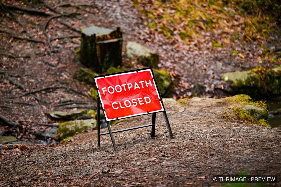 Red Footpath Closed sign blocking a damp woodland trail